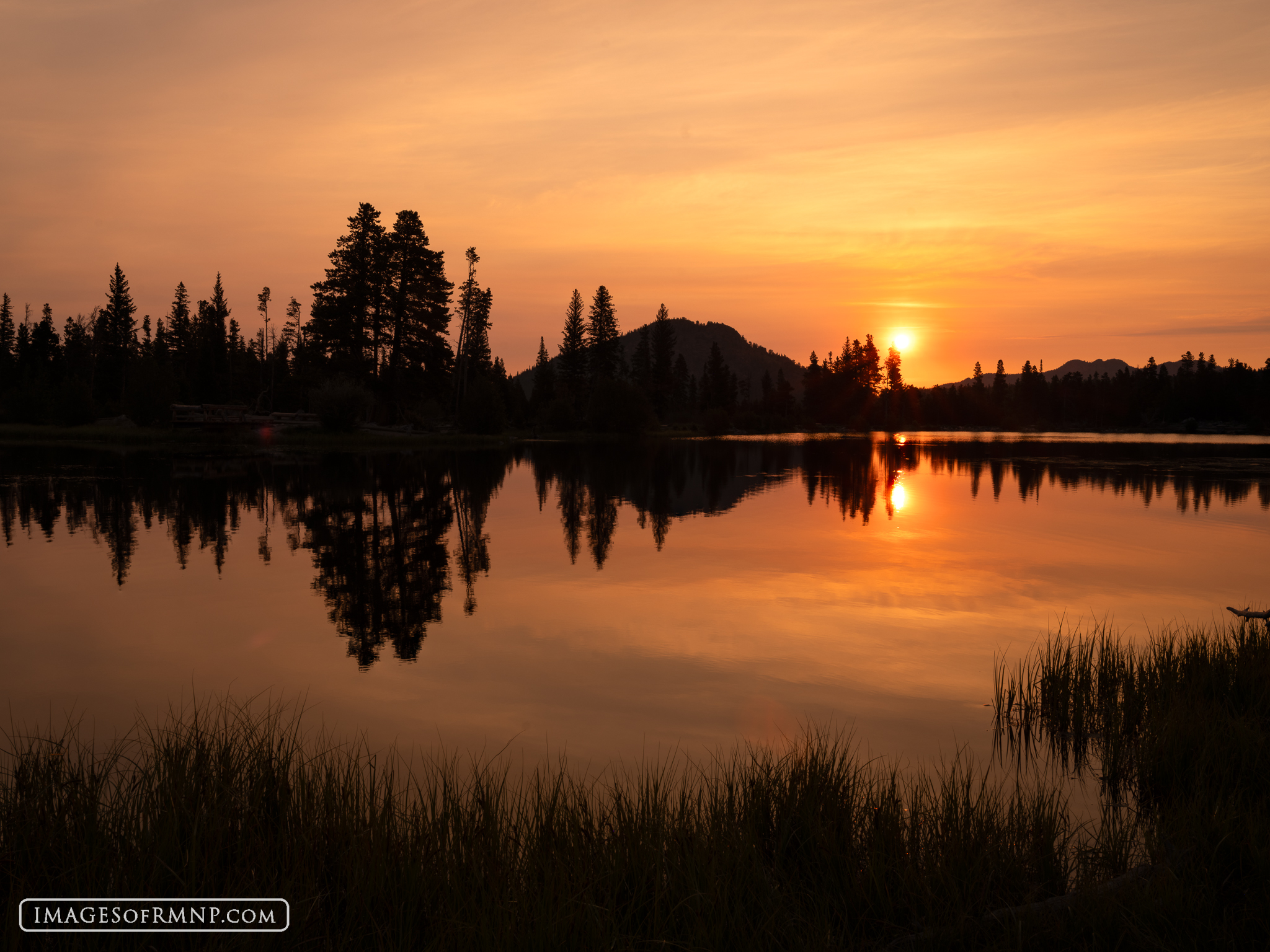 July 6, 2026 A smoke-filled sky makes for a colorful sunrise at Sprague Lake on a perfectly calm July morning. 